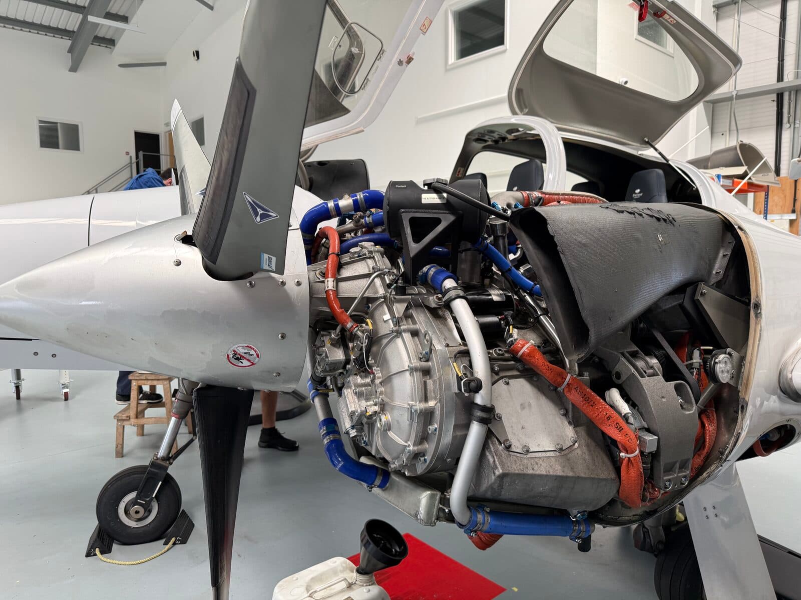 A Diamond aircraft with its engine cowling removed for maintenance